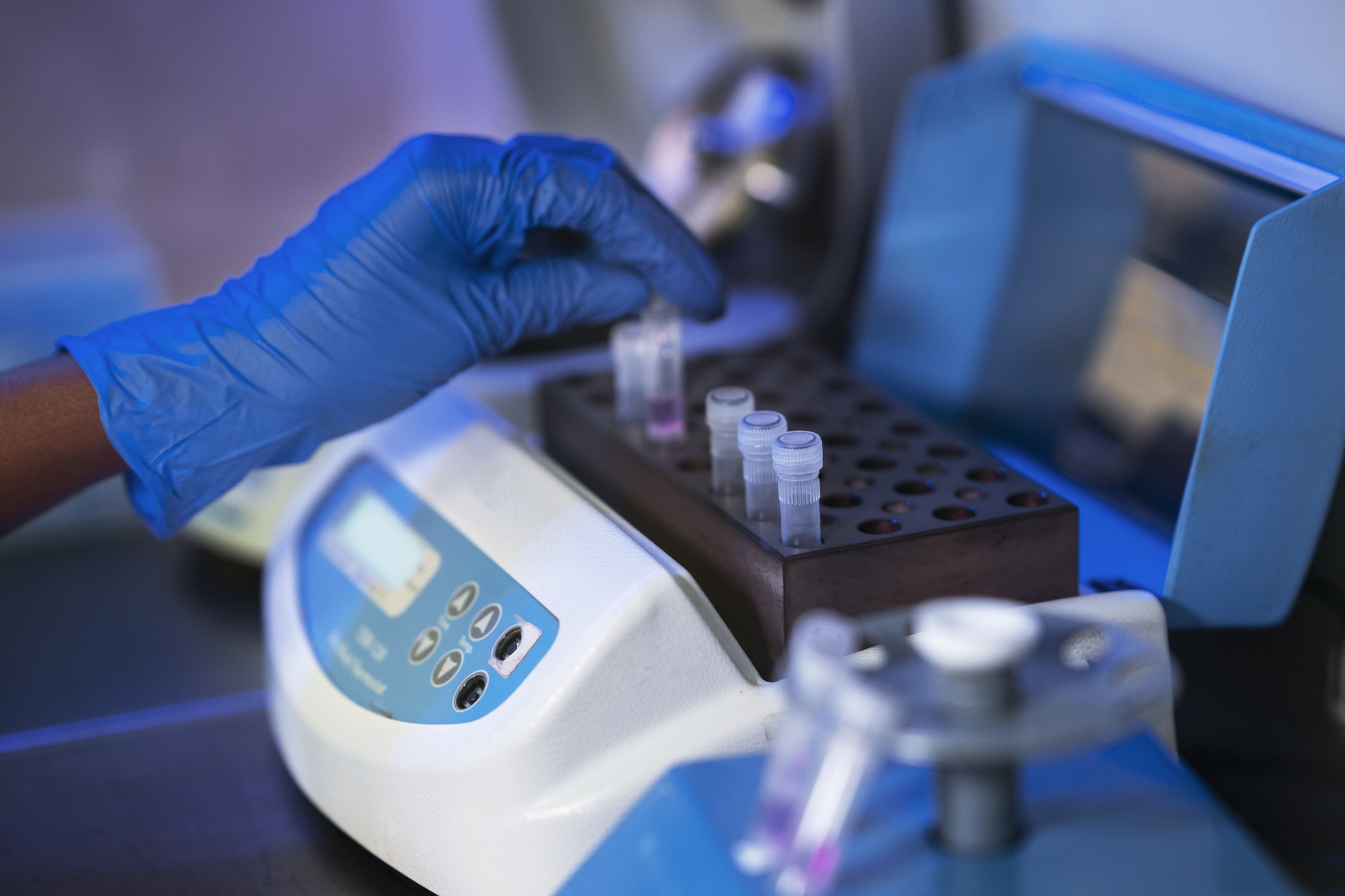 یک محقق درحال تجزیه و تحلیل ژن‌ها با استفاده از دستگاه PCR است.