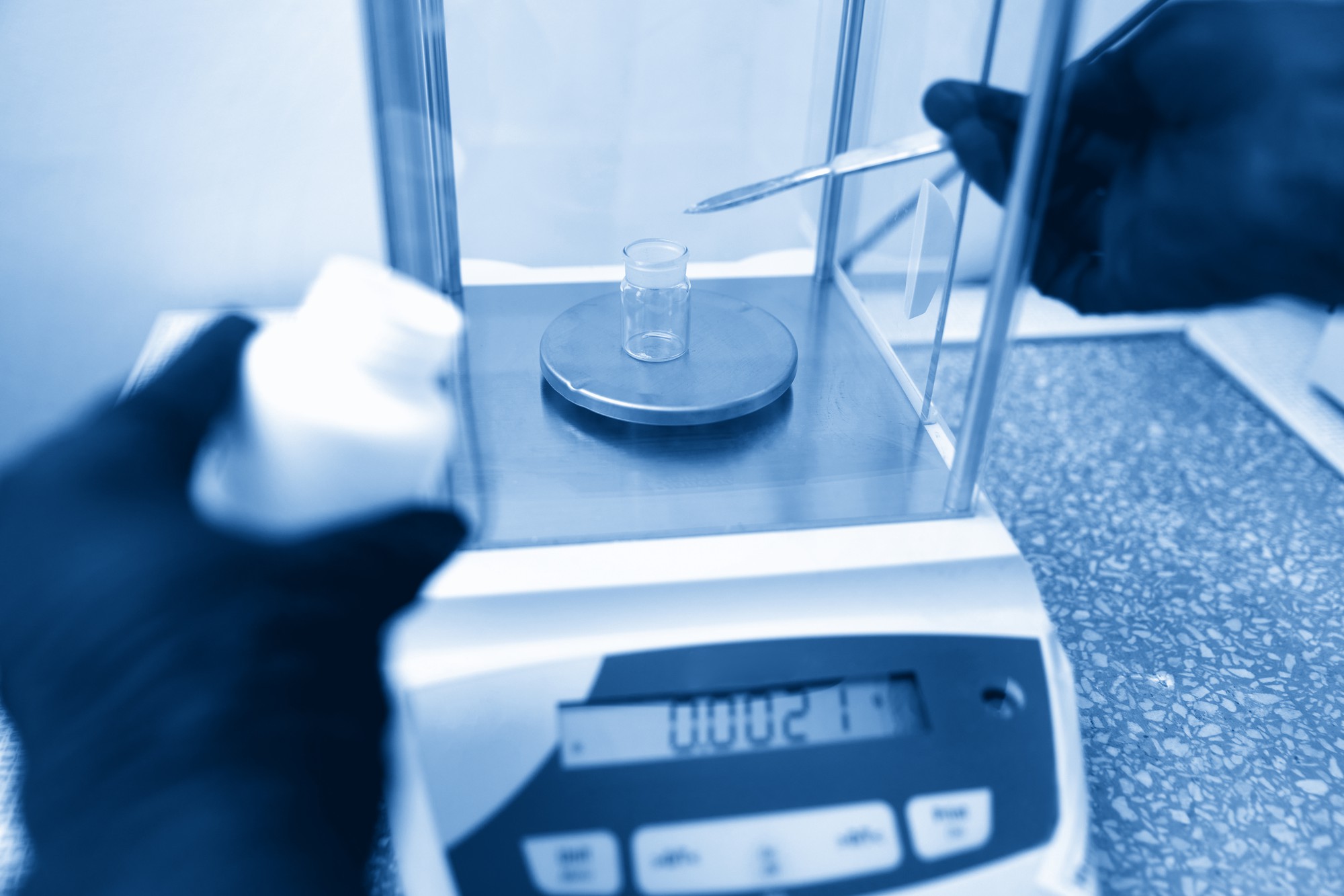 یک محقق با استفاده از ترازوی تحلیلی درحال بررسی وزن یک محلول است.